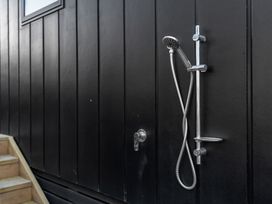 An outdoor shower on a black wall at Waihi Beach Holiday Home in Waihi Beach