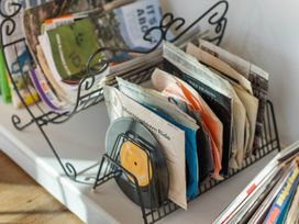 A collection of magazines and vinyl records in a holder at Waihi Beach Holiday Home in Waihi Beach