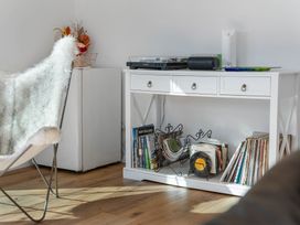 A living room with a side table and records at Waihi Beach Holiday Home, Waihi Beach