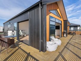 An outdoor patio area with a table and chairs at Waihi Beach Holiday Home in Waihi Beach