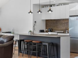 A kitchen with a bar counter and stools at Waihi Beach Holiday Home in Waihi Beach