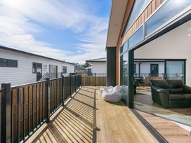 A deck area with a railing and bean bags at Waihi Beach Holiday Home in Waihi Beach