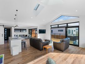 A living room with a sofa and television at Waihi Beach Holiday Home in Waihi Beach