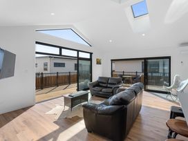 A living room with a sofa and television at Waihi Beach Holiday Home in Waihi Beach