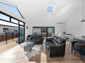 A living room with a sofa and coffee table at Waihi Beach Holiday Home in Waihi Beach