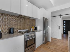 A kitchen with appliances and cabinets at Waihi Beach Holiday Home in Waihi Beach