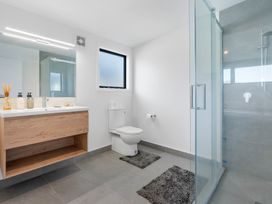 A bathroom with a sink, toilet, and shower at Waihi Beach Holiday Home in Waihi Beach
