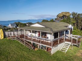 A house with a deck and kayak near the ocean at Quail Rise - Collingwood Holiday Home Collingwood