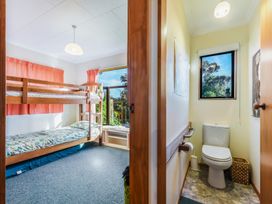 A bedroom with a bunk bed and a bathroom with a toilet at Quail Rise - Collingwood Holiday Home Collingwood