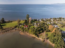 An aerial view of a coastal area with houses and vegetation at Quail Rise - Collingwood Holiday Home Parapara Beach