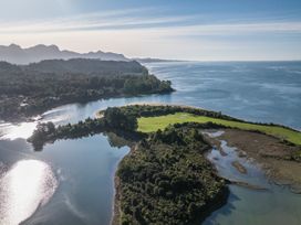 A landscape featuring a river and surrounding trees at Quail Rise - Collingwood Holiday Home Parapara Beach