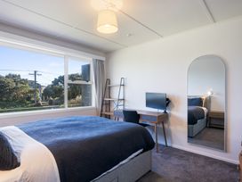 A bedroom with a bed a desk and a television at The Beach Base - Paraparaumu Holiday home Paraparaumu