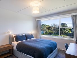 A bedroom with a bed and window at The Beach Base - Paraparaumu Holiday home Paraparaumu