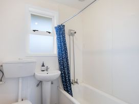 A bathroom with a toilet, sink, and shower at The Beach Base - Paraparaumu Holiday home Paraparaumu