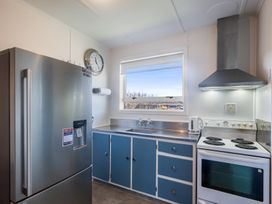A kitchen with a refrigerator and stove at The Beach Base - Paraparaumu Holiday home in Paraparaumu