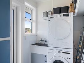 A laundry room with a washing machine and dryer at The Beach Base - Paraparaumu Holiday home Paraparaumu