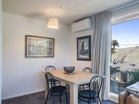 A dining room with a table and chairs at The Beach Base - Paraparaumu Holiday home Paraparaumu