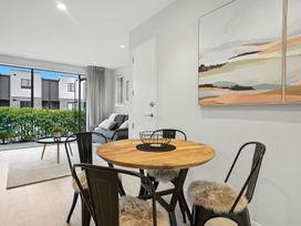 A living room with a dining table and chairs at Townheart on Hereford - Christchurch City Apartment