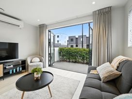 A living room with a television and a coffee table at Townheart on Hereford - Christchurch City Apartment