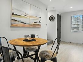 A dining area with a round table and chairs at Townheart on Hereford - Christchurch City Apartment