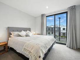 A bedroom with a bed and window at Townheart on Hereford - Christchurch City Apartment