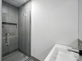 A bathroom with a shower and sink at Townheart on Hereford - Christchurch City Apartment