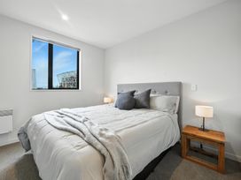 A bedroom with a bed and nightstand at Townheart on Hereford - Christchurch City Apartment