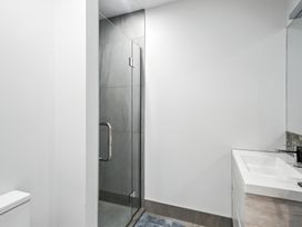 A bathroom with a shower and sink at Townheart on Hereford - Christchurch City Apartment