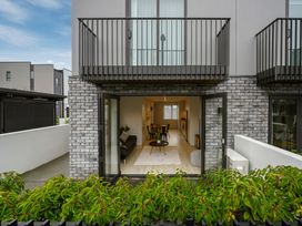 A living room with a balcony and dining area at Townheart on Hereford - Christchurch City Apartment