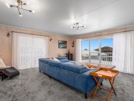 A living room with a blue sofa and a table at Ohope in Ohope