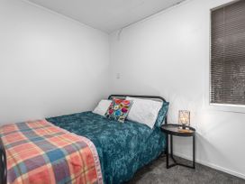 A bedroom with a bed and nightstand at Ohope in Ohope
