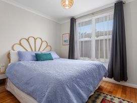 A bedroom with a bed and curtains at Ohope in Ohope