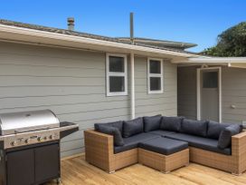 An outdoor area with a barbecue grill and a wicker sofa at Ohope in Ohope