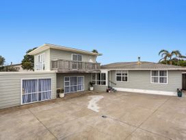 A house with a balcony and driveway at Ohope in Ohope