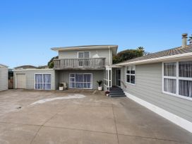 An outdoor view of a house with a balcony and garage at Ohope
