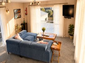 A living room with a sofa and coffee table at Coastal Haven Retreat - 4 Bedrooms Ohope Beach