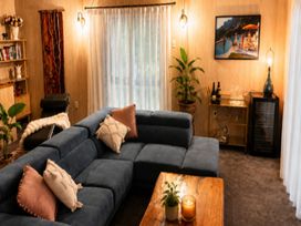 A living room with a sofa and coffee table at Coastal Haven Retreat - 4 Bedrooms Ohope Beach