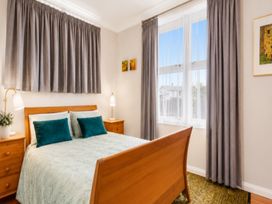 A bedroom with a bed and nightstand at Coastal Haven Retreat - 4 Bedrooms Ohope Beach
