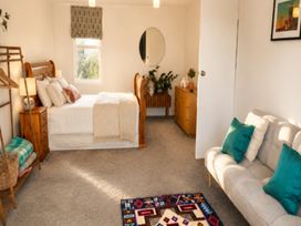 A bedroom with a bed, sofa, and plants at Coastal Haven Retreat - 4 Bedrooms Ohope Beach