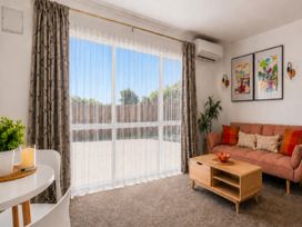 A living room with a sofa and coffee table at Coastal Haven Retreat - 4 Bedrooms Ohope Beach