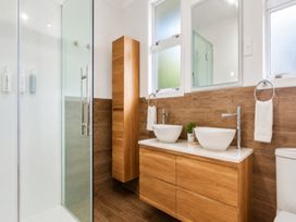 A bathroom with a shower and two sinks at Coastal Haven Retreat - 4 Bedrooms Ohope Beach