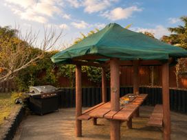 A gazebo with a table and grill in the garden at Coastal Haven Retreat - 4 Bedrooms Ohope Beach