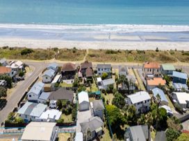 An aerial view of houses near the beach at Coastal Haven Retreat - 4 Bedrooms Ohope Beach