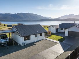 A view of houses and a lake surrounded by mountains at The Tranquil Edge - Te Anau Holiday Home in Te Anau