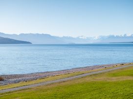 A view of a lake with mountains in the background at The Tranquil Edge - Te Anau Holiday Home, Te Anau