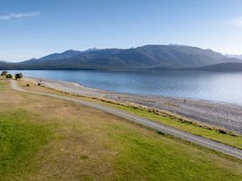 A view of a beach and mountains at The Tranquil Edge - Te Anau Holiday Home in Te Anau