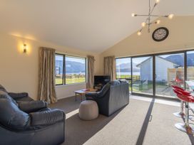 A living room with a sofa and a television at The Tranquil Edge - Te Anau Holiday Home Te Anau