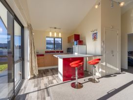 A kitchen with red bar stools and appliances at The Tranquil Edge - Te Anau
