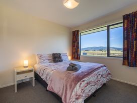 A bedroom with a bed and bedside lamp at The Tranquil Edge - Te Anau