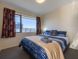 A bedroom with a bed and window at The Tranquil Edge - Te Anau Holiday Home Te Anau